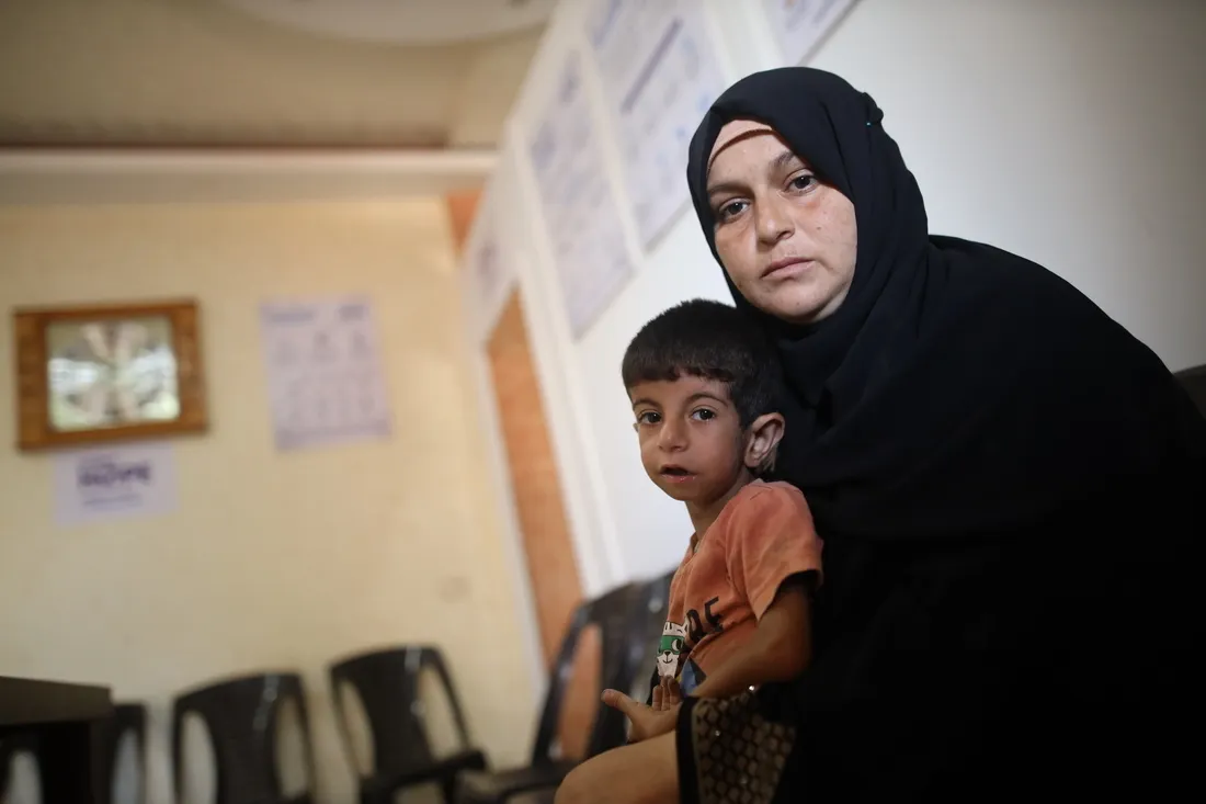 mother holds young son in Gaza inside of clinic